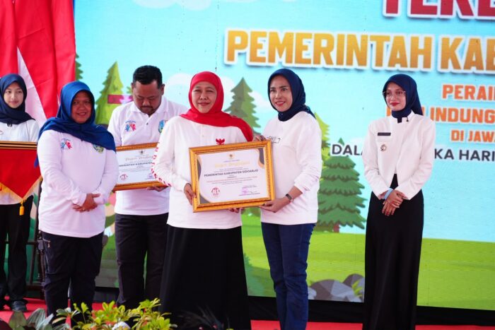 Keterangan Foto : Gubernur Jawa Timur Khofifah Indar Parawansa (kiri) menyerahkan penghargaan Indeks Perlindungan Anak (IPA) Terbaik II Jawa Timur kepada Wakil Bupati Sidoarjo Hj. Mimik Idayana (kanan) pada Puncak HAN Provinsi Jatim di Wisata Alam Pintu Langit Pasuruan.